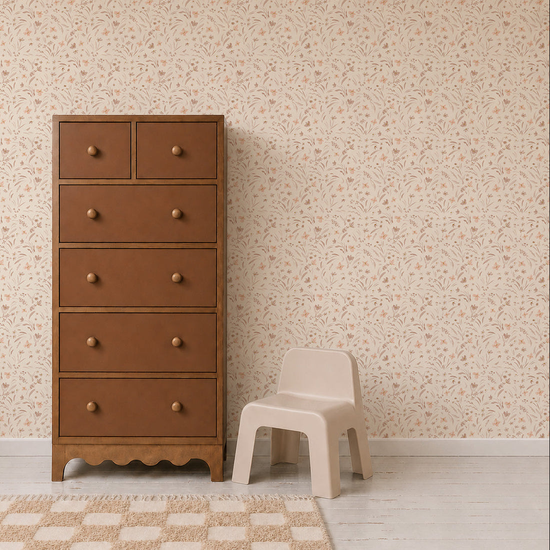 A brown wooden dresser stands next to a small beige chair on a light wood floor, with Butterfly Meadowland Wallpaper in Dune adding a touch of nature and a checkered rug completing the room.