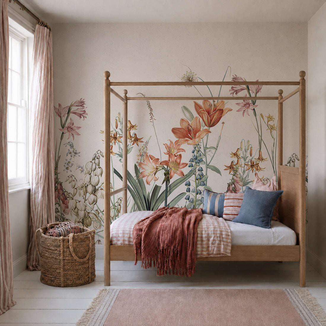 A cozy bedroom features a wooden canopy bed dressed in pastel bedding, topped with a rust-colored throw and matching pillows. The wall showcases the Quinns Flower Field Mural, bringing the vibrant look of a blooming garden indoors. Next to the window with pink curtains, a woven basket adds an extra touch of warmth.