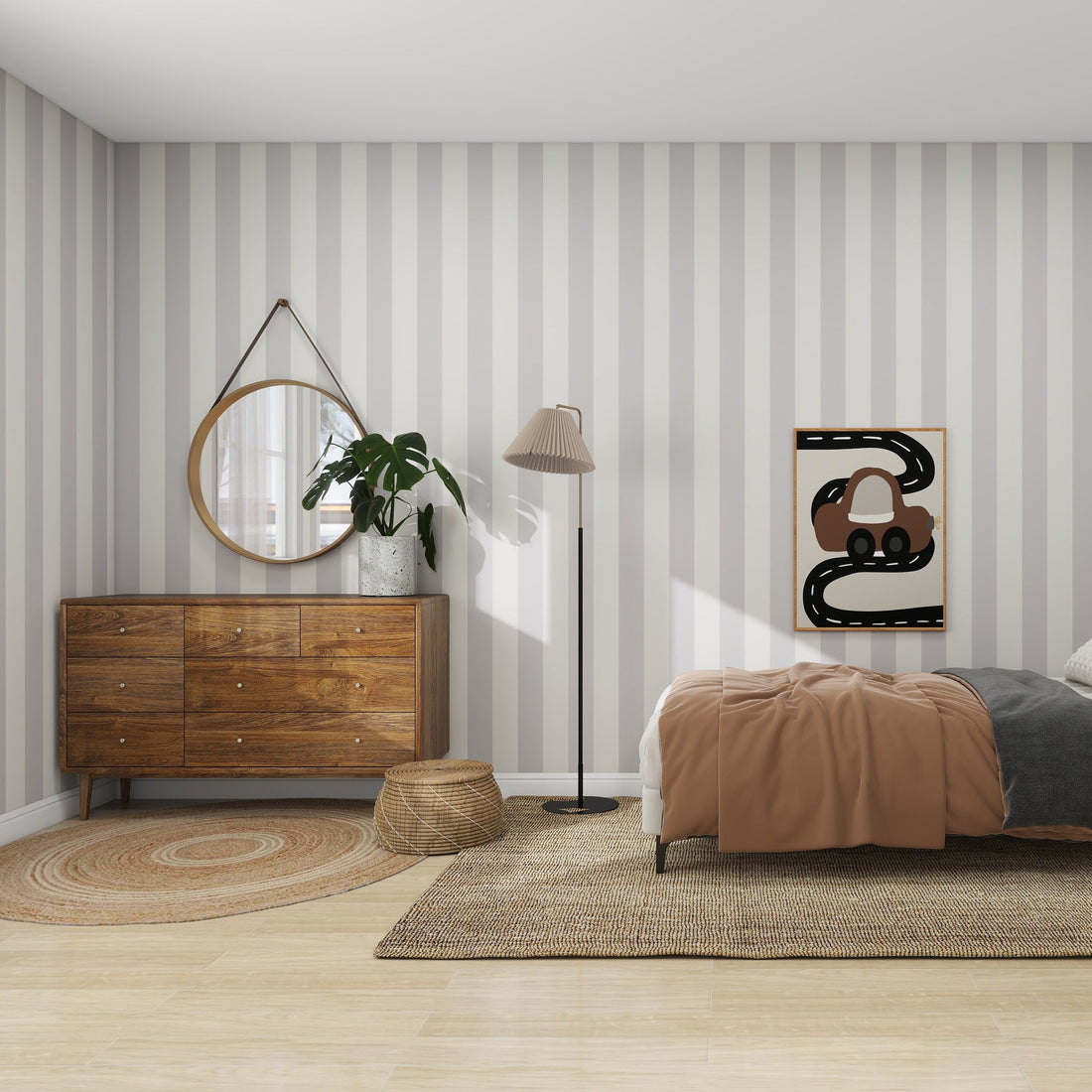 A modern bedroom includes a wooden dresser with a round mirror, a potted plant, and a woven basket. The bed is dressed with brown and gray bedding next to a standing lamp. The rooms charm is enhanced by munks and mes Circus Stripe Wallpaper Stone, alongside abstract art and a circular rug.