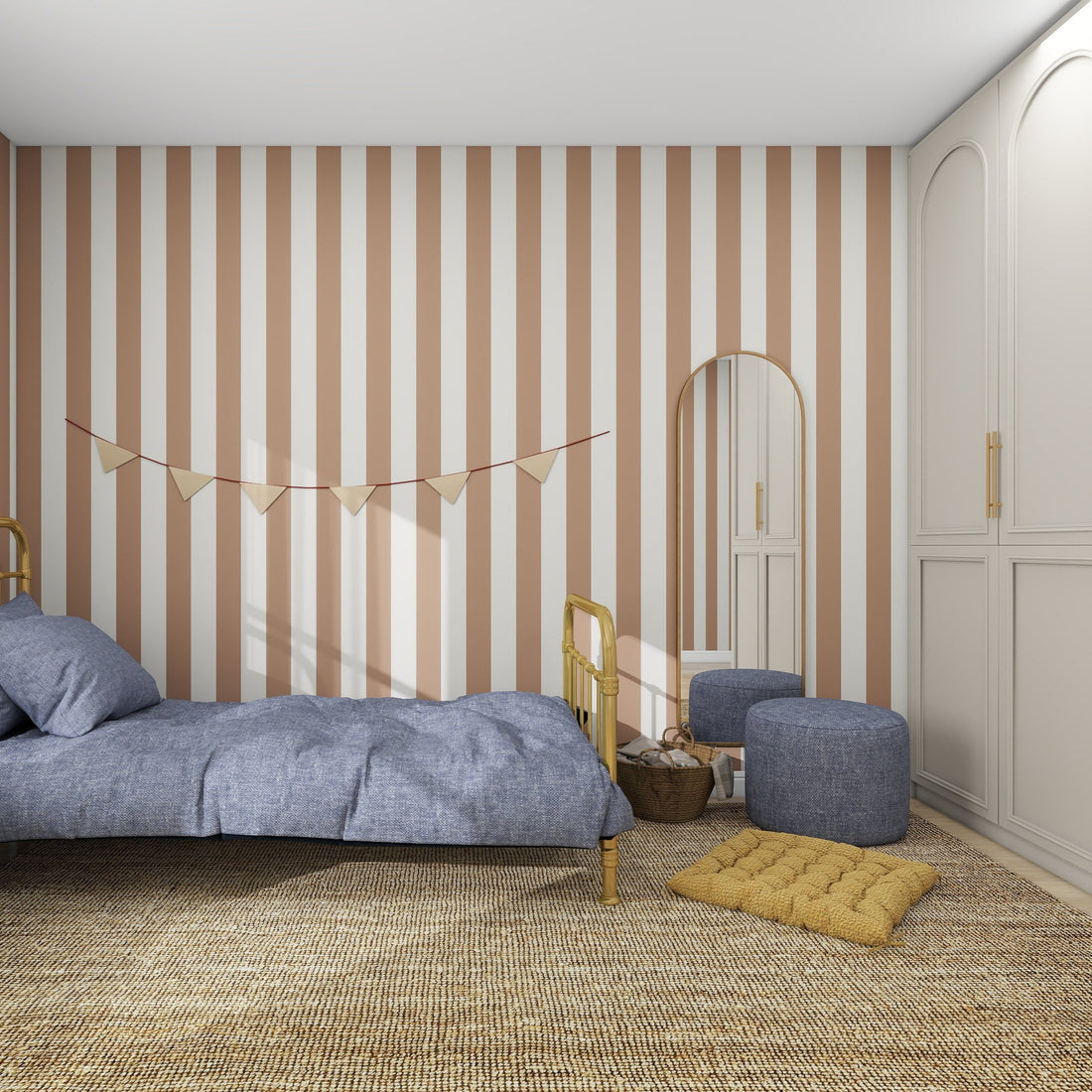 The bedroom features Circus Stripe Wallpaper Latte from munks and me, accented by a bed with blue bedding, two blue ottomans, and a yellow cushion. A mirror adorns the wall alongside decorative bunting, while a neutral woven rug grounds this playful yet sophisticated kids space.