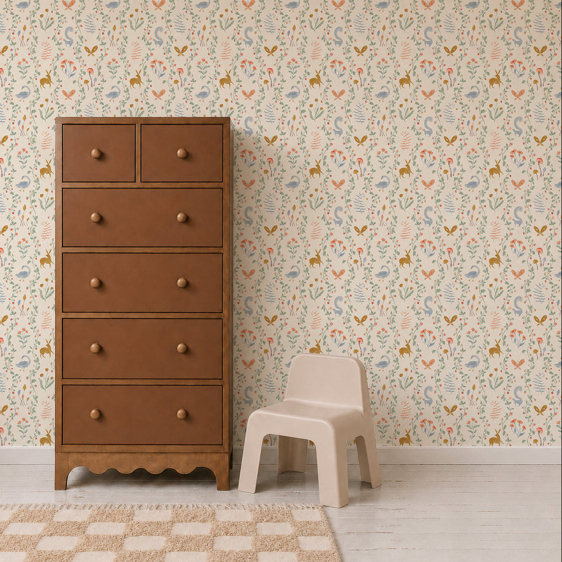A tall brown dresser and a small beige plastic chair sit on a light-colored floor. The wall features Coles Berry Patch Wallpaper, with whimsical floral designs and pastel animal patterns that create a playful atmosphere. A beige and white checkered rug lies in front.