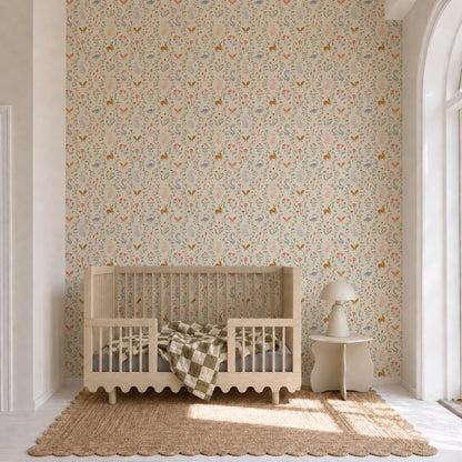 A wooden crib sits on a woven rug in a bright nursery adorned with Coles Berry Patch Wallpaper. A green and white checkered blanket hangs over the crib rail, next to a small table with a lamp by a large arched window.