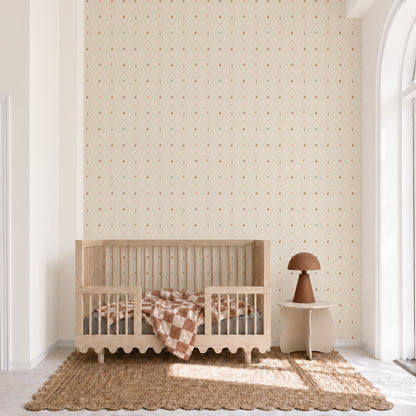 A neutral-toned nursery featuring a wooden crib, a brown checkered blanket, a small round side table, a brown lamp, a jute rug, and walls adorned with Little Patisserie Stripe Wallpaper. Sunlight streams in from a large arched window on the right.
