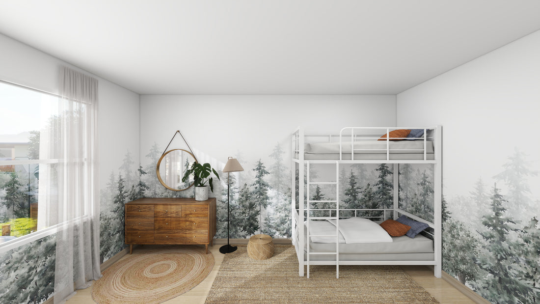 The bedroom exudes serenity with the Walk In The Forest Wallpaper Mural by munks and me. A white metal bunk bed, round rug, wooden dresser with a round mirror and potted plant complement it. A floor lamp by the large window with sheer curtains completes the tranquil decor.