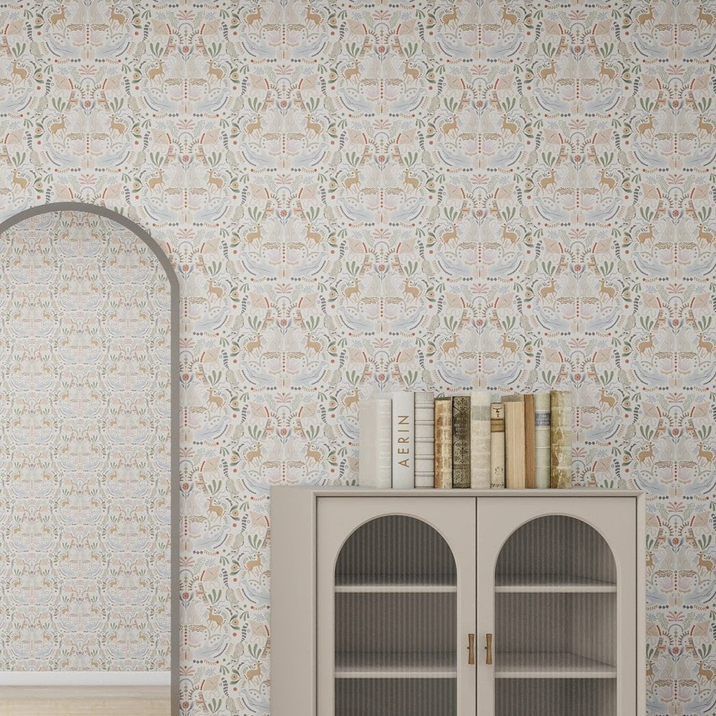 The room showcases a cabinet with glass doors and books on top. Behind it, the wall features the Creatures Great and Small Wallpaper Repeat Pattern by munks and me, adorned with an adorable animal menagerie, while an arched mirror reflects this whimsical design.