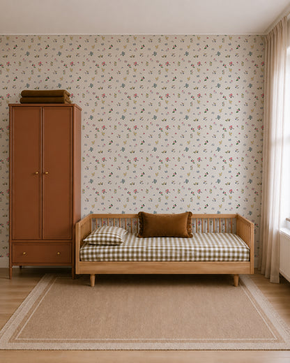 A cozy, minimalist bedroom with a daybed featuring checked bedding, a brown cushion, a rust-colored wardrobe, Powdered Petals Wallpaper with hand-drawn florals, a beige rug, and a large window with light curtains.