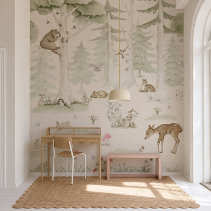 A children’s room features a wooden desk, chair, and bench. The wall is decorated with the whimsical Woodland Friends Mural, adorned with bears, deer, rabbits, and trees. A pendant lamp hangs above, while a woven rug rests on the floor.