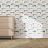 A light wood dresser stands on a woven rug before a white wall covered with Crocodile Wallpaper Repeat Pattern in vibrant colors, creating a playful look as sunlight casts soft shadows across the scene.