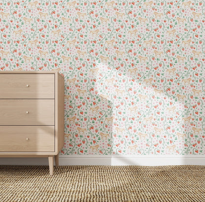 A light wood dresser with three drawers stands on a woven rug against nursery wallpaper featuring the Strawberry Horses Wallpaper Repeat Pattern in soft orange, green, and pink, creating a cozy vibe perfect for childrens spaces.
