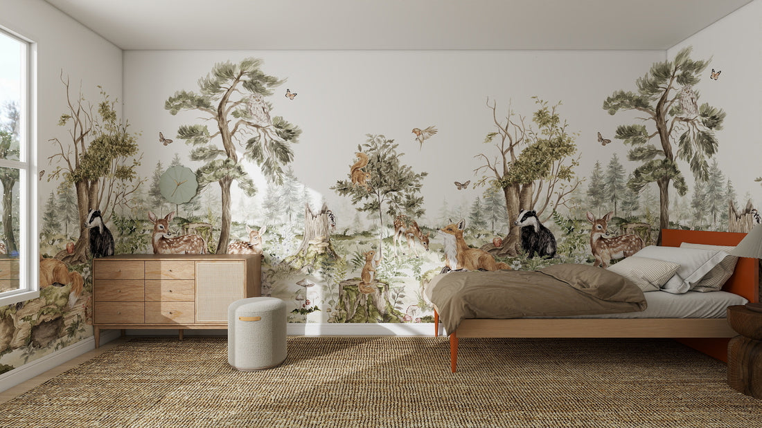 A cozy bedroom features the Into The Forest Wallpaper Mural Sample in stunning quality, showcasing trees, deer, foxes, owls, and butterflies. Sunlight streams onto the bed, nightstand, dresser, and woven rug through a large window.