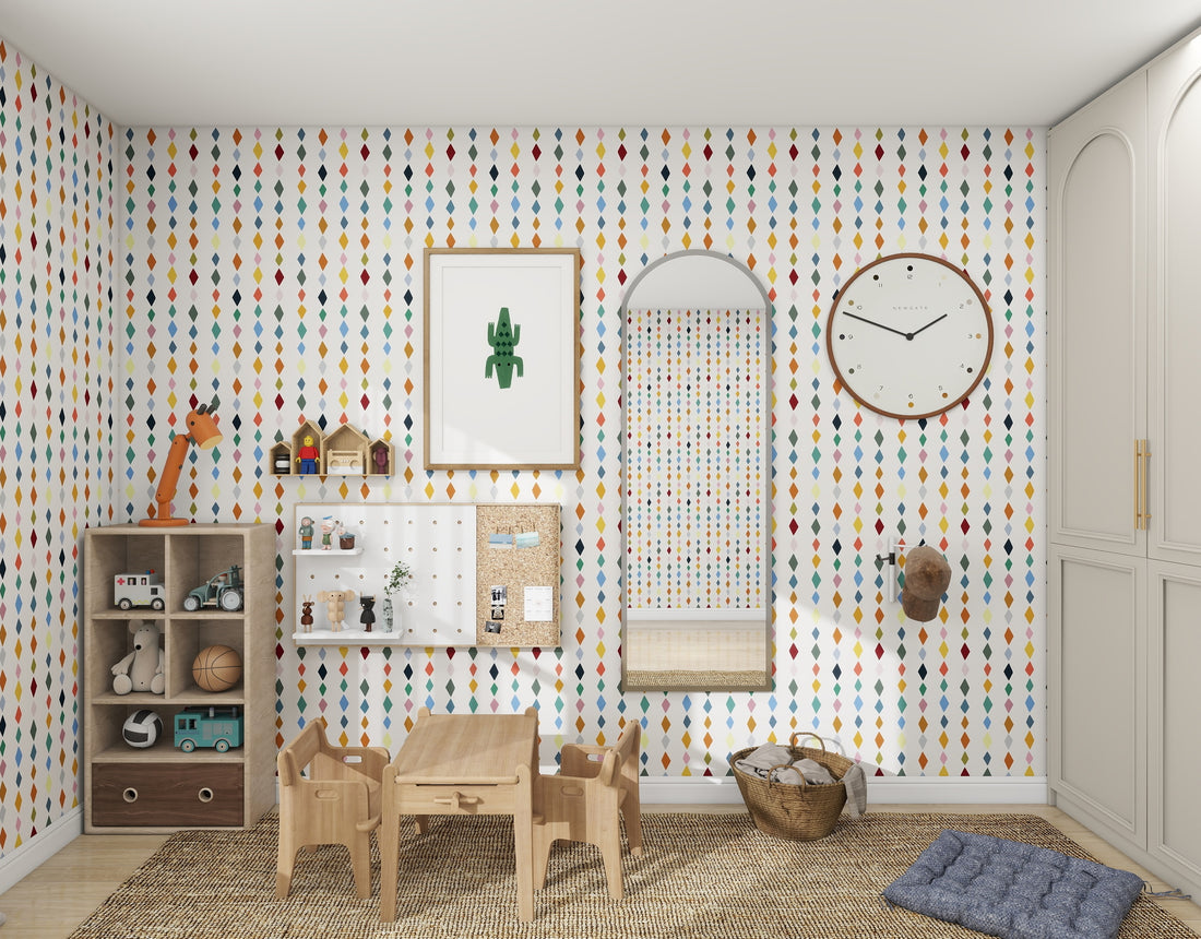 The childrens room exudes a lively vibe with munks and mes Jolly Jester Wallpaper Repeat Pattern | Multi, featuring multicolored raindrops. It includes a wooden table with chairs, wall shelves, a large mirror, round clock, toys, a woven rug, and a wicker basket for added playfulness.