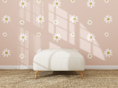 A white ottoman sits on a woven rug before a pink wall featuring the Custom Large Daisy Floral Wallpaper Repeat Pattern. Sunlight pours in, casting shadows and accentuating the wallpaper’s playful daisy motifs.