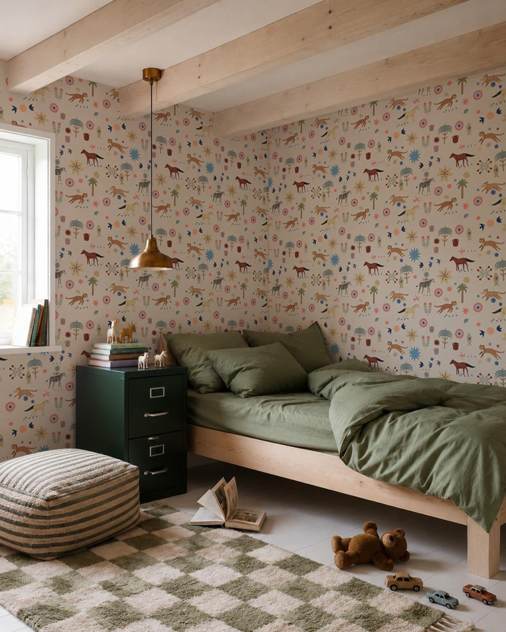 A cozy bedroom with green bedding on a wooden bed, a checkered rug, toys, books, and nursery walls decorated with Little Wanderers Wallpaper featuring colorful animals. Sunlight pours in through the window.