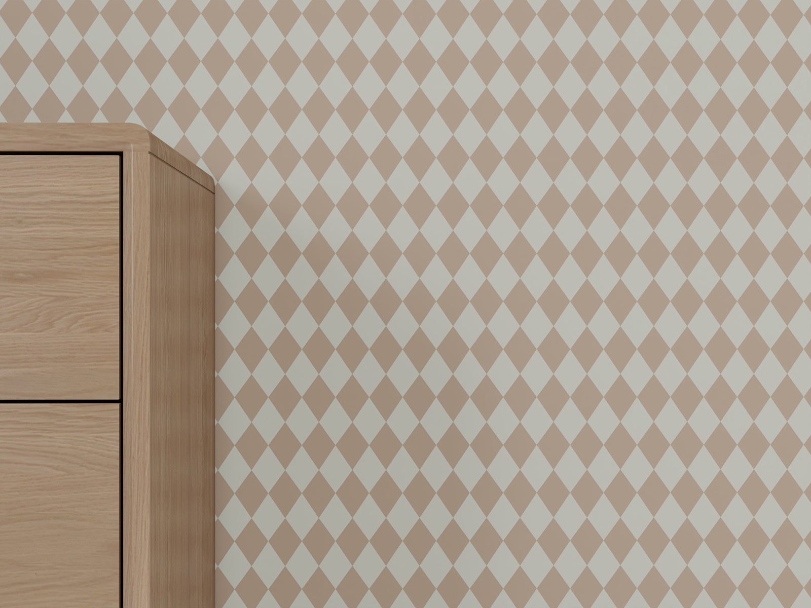A wooden dresser stands against a wall covered in Diamond Dancer Wallpaper, Rose. Only the left side of the dresser is visible, while the geometric pattern extends across the rest of the wall.