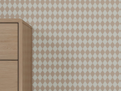 A wooden dresser stands against a wall covered in Diamond Dancer Wallpaper, Rose. Only the left side of the dresser is visible, while the geometric pattern extends across the rest of the wall.