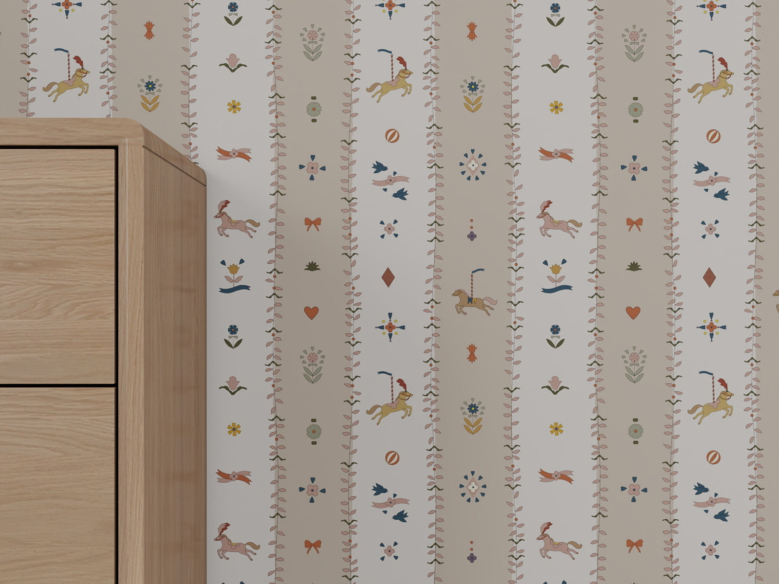 A section of The Little Carousel Stripe Wallpaper, Rose, with vertical stripes in light hues and whimsical unicorns, birds, flowers, hearts, and other motifs; a light wooden cabinet appears partially on the left.
