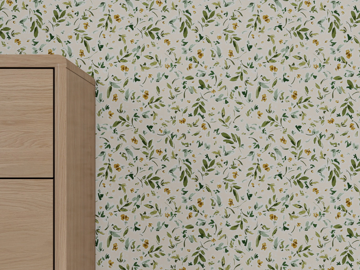 A close-up of a light wood cabinet beside a wall covered with Meadow Flutter Leaves Wallpaper in cream, featuring a green and yellow floral pattern for nature-inspired kids room decor.