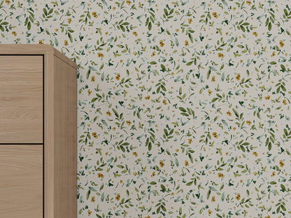 A close-up of a light wood cabinet beside a wall covered with Meadow Flutter Leaves Wallpaper in cream, featuring a green and yellow floral pattern for nature-inspired kids room decor.