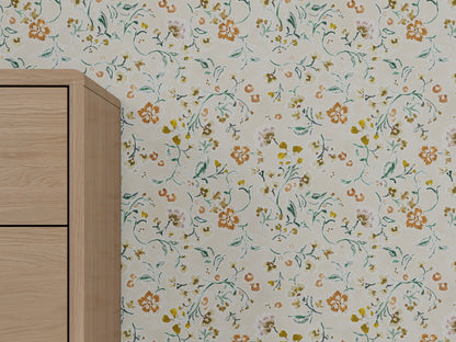 A light wall features Terra Bloom Wallpaper with hand-painted orange, yellow, and green florals. On the left is a corner of a light wood cabinet with clean, simple lines.