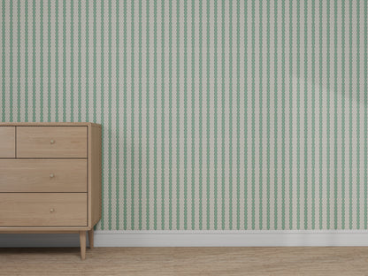 A wooden dresser sits on a carpeted floor next to a wall decorated with Custom Green Seafoam Abacus Stripe Wallpaper, highlighting its elegant green and white striped pattern.