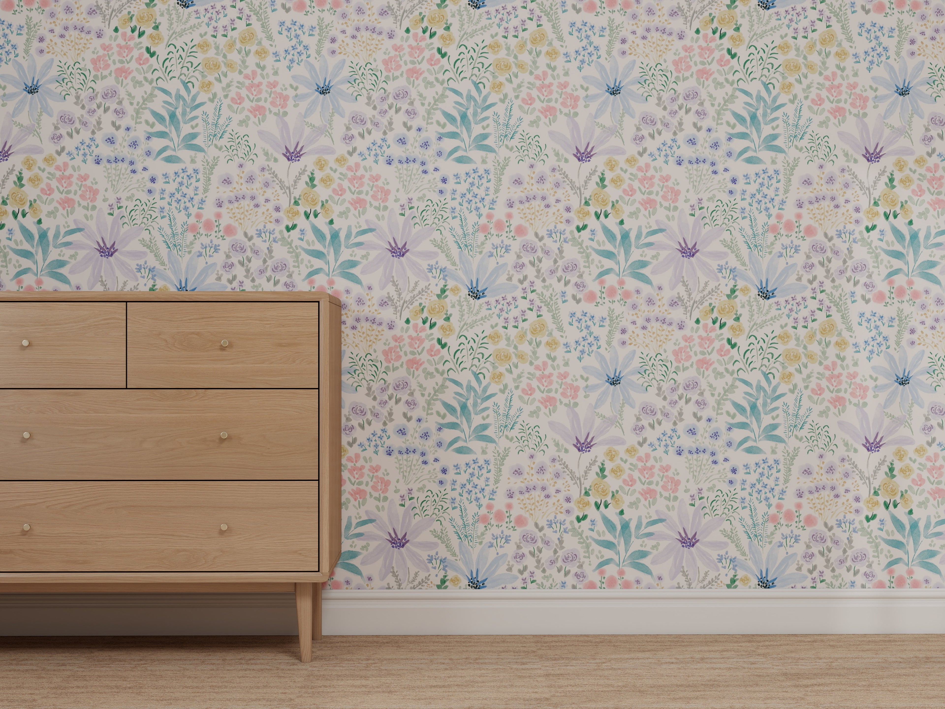 A light wooden dresser with four drawers stands on a beige carpet, backed by Custom Wildflower Waltz Wallpaper | Sample, which features colorful pastel flowers and green leaves in a high-quality floral pattern.
