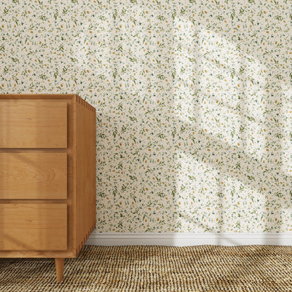 A light wooden dresser stands on a beige carpet beside a wall decorated with Meadow Flutter Leaves Wallpaper. Sunlight highlights the leafy patterns, giving the kids&