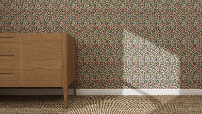 A wooden dresser on a woven carpet stands by a wall adorned with Midnight Meadow Florals Wallpaper. Sunlight brightens the dense floral patterns, showcasing the wallpaper’s quality as a bright patch of light falls across the design.