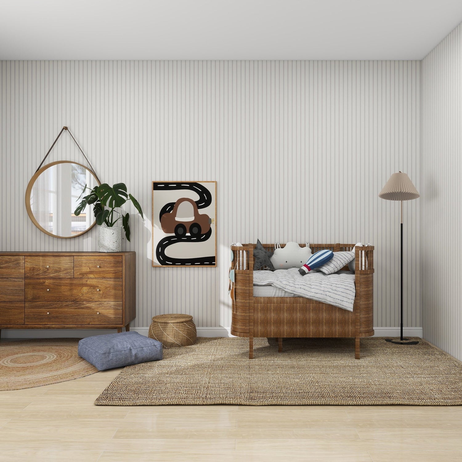 A cozy nursery features a wicker crib with pillows and a blanket, a wooden dresser adorned with a round mirror and plant, and munks and mes Pinstripe Wallpaper Stone samples enhancing the rooms neutral palette. A floor lamp, woven baskets, and art complete the decor with wood and woven textures.