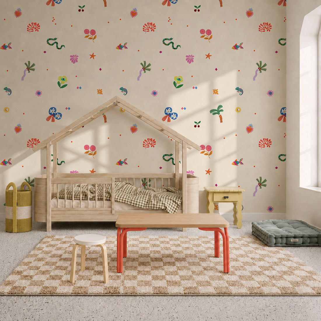 A children’s room with a wooden house-shaped bed, checkered rug, small table and stools, green floor cushion, and playful Doodle Dreams Mural wallpaper featuring colorful flowers, butterflies, and shapes. Sunlight streams through a large window.