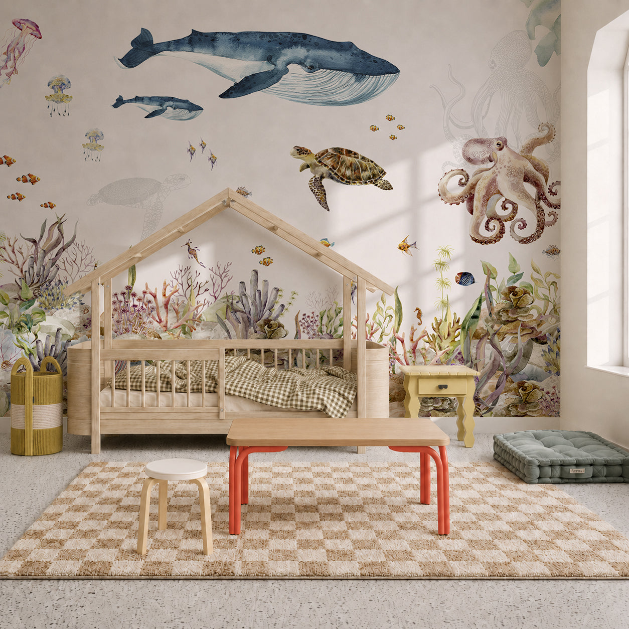 Children’s room with the Under The Sea Mural, Watercolour, featuring enchanting whales, turtles, and an octopus. There’s a wooden bed shaped like a house, a checkered rug, small tables, and playful decor that captures the magic of an underwater world.