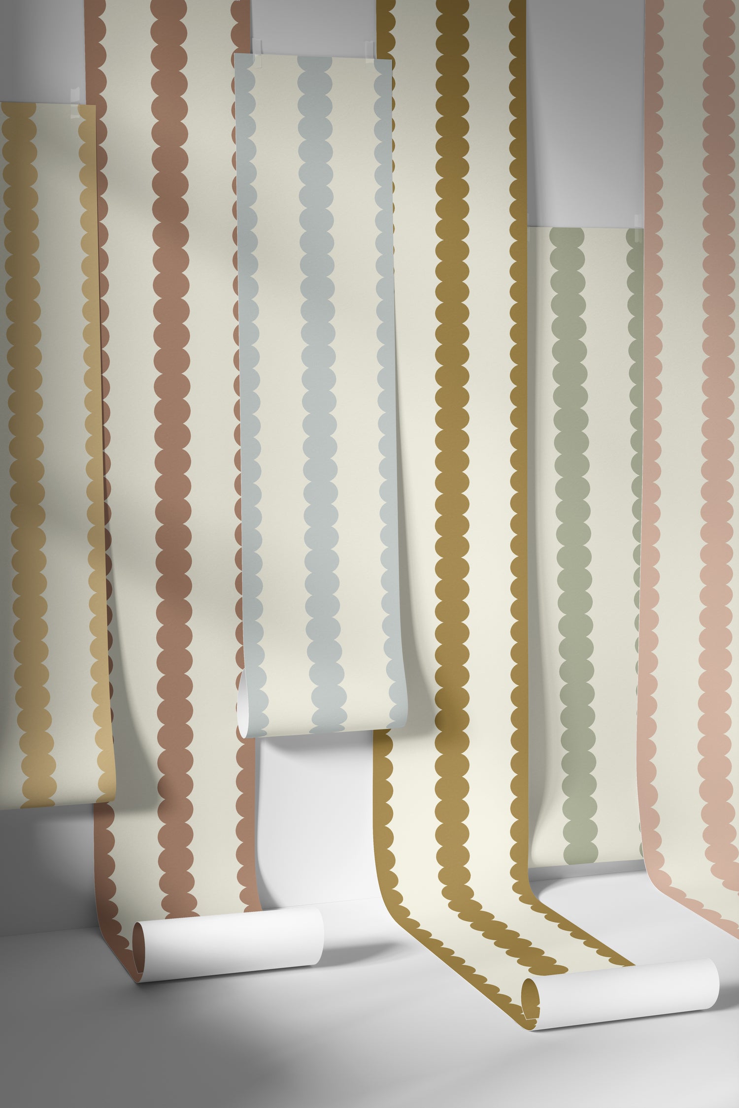 Vertical rolls of Scallop Stripe Wallpaper Blue by munks and me feature a scalloped edge pattern in colors such as brown, beige, green, and blue, casting shadows that add depth and charm to any nursery.