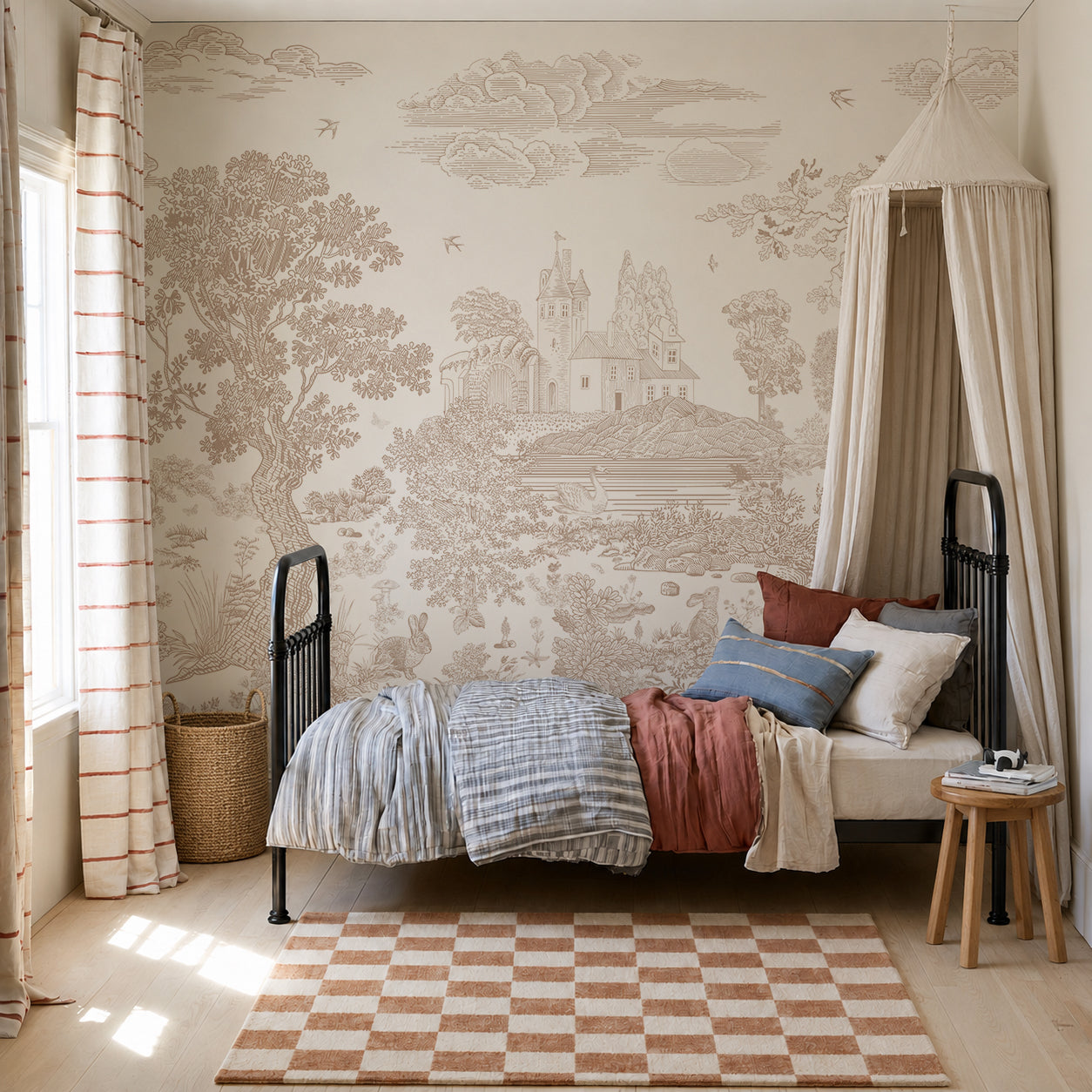 Cozy bedroom featuring a black metal bed, patterned bedding, throw pillows, a round cushioned bench, striped curtains, and a wicker basket. The wall is adorned with the Forest Hideaway Mural in Neutral, while natural light from the window brightens the space.