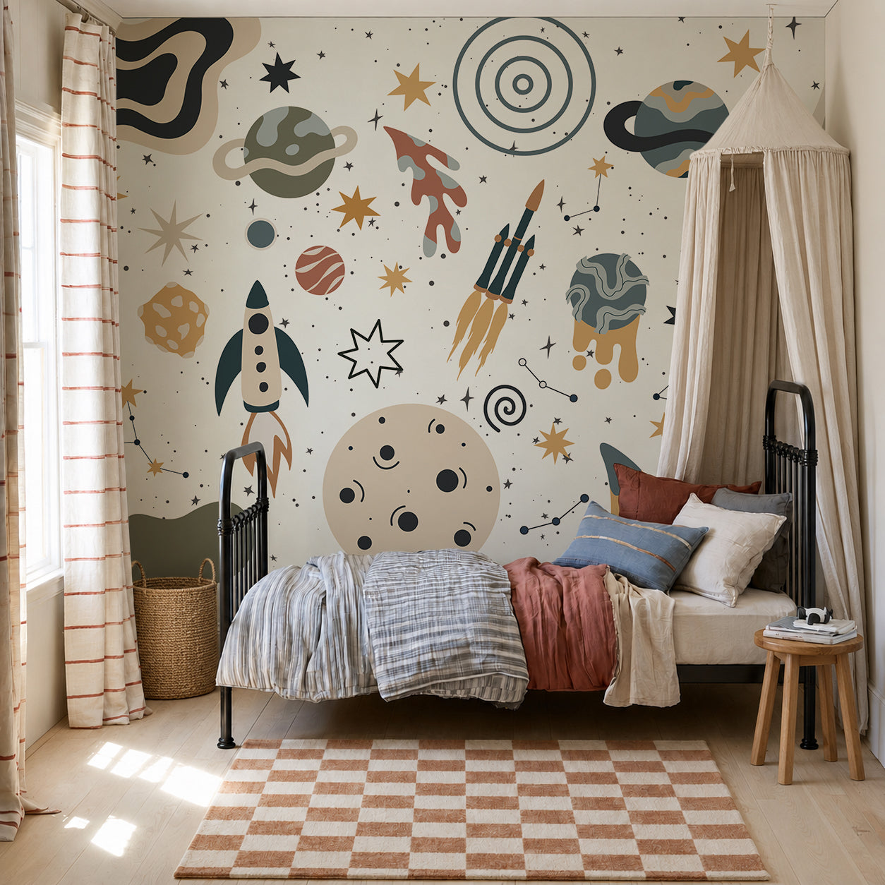 A cozy kids’ bedroom featuring a bed with striped bedding, a canopy, pillows, a striped rug, and a basket is adorned with the To The Moon Mural, showcasing rockets, planets, and stars in muted colors. Sunlight streams in from a window on the left.