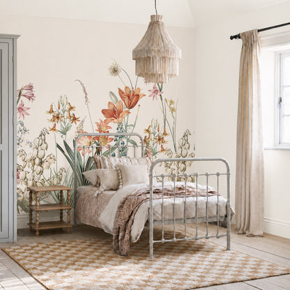 Bedroom with a metal-framed bed, beige bedding, checkered rug, side table, floral wallpaper mural, hanging woven light, beige curtains, and sunlight coming through a window creates an inviting retreat. The Quinns Flower Field Mural serves as the elegant floral wallpaper mural in this space, adding a touch of Spring Garden Wall Decor and bringing the beauty of a blooming garden indoors.