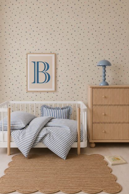 A cozy nursery featuring a small white crib, blue striped bedding, a wooden dresser, a blue lamp, a framed letter B, a scalloped rug, and a book on the floor. The walls are adorned with Soaring Hearts Wallpaper, which adds charm and warmth to the room.