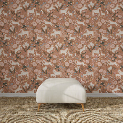 A white ottoman sits on a woven rug in front of Unicorn Meadow Wallpaper Toffee Rose, featuring pink florals, white horses, and leafy patterns for an exquisite look.
