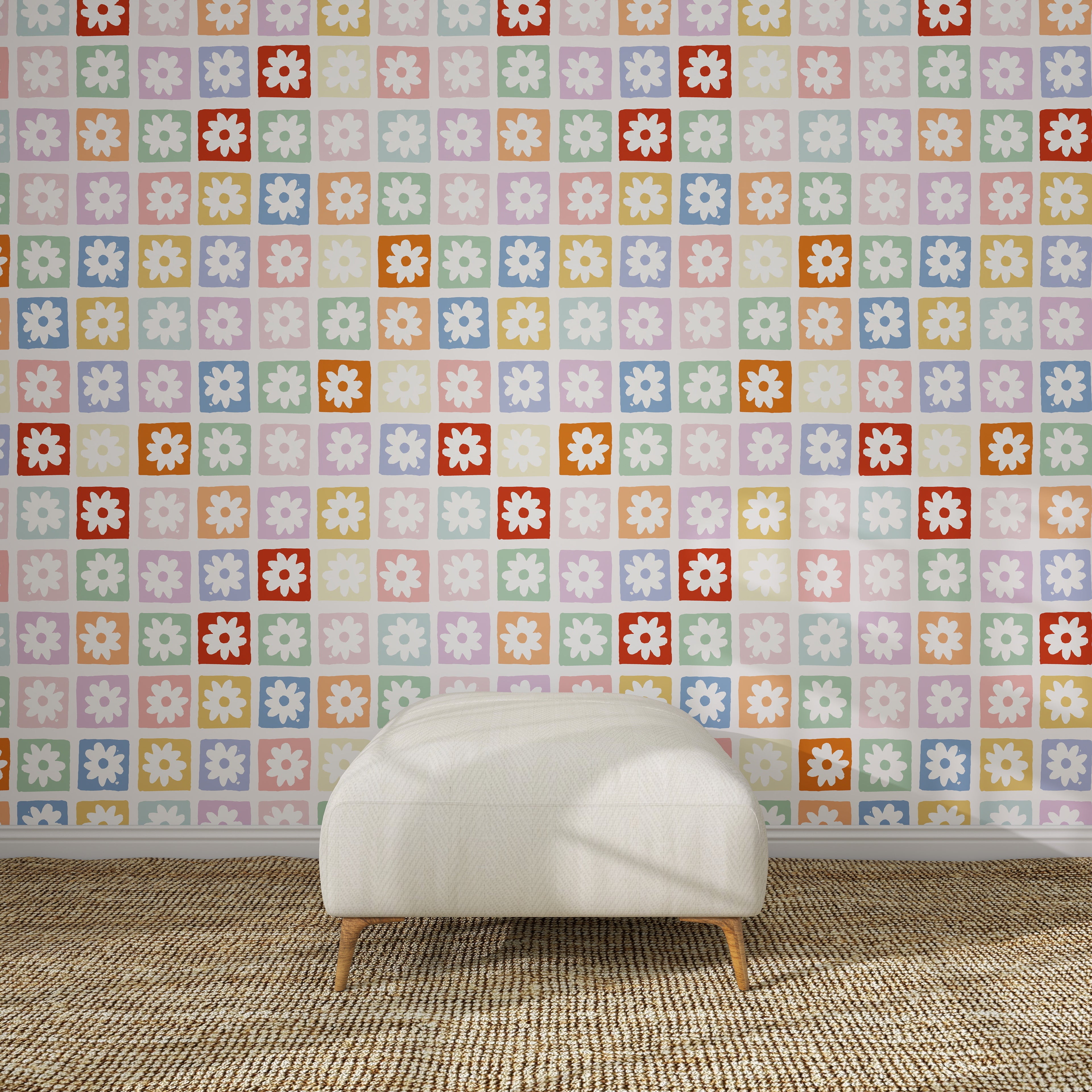 A white textured ottoman rests on a woven rug before a wall adorned with the "Floral Fun land Repeat Wallpaper Pattern | Sample," featuring vibrant, geometric floral designs in a colorful grid arrangement.