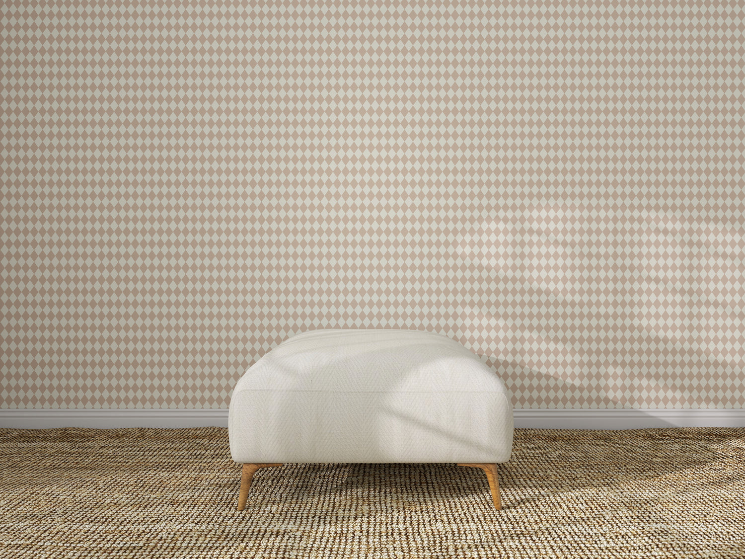 A minimalist room features a light-colored bench with wooden legs on a textured carpet, set against a wall adorned with Diamond Dancer Wallpaper in Rose, showcasing hand-drawn harlequin diamonds in beige and white.
