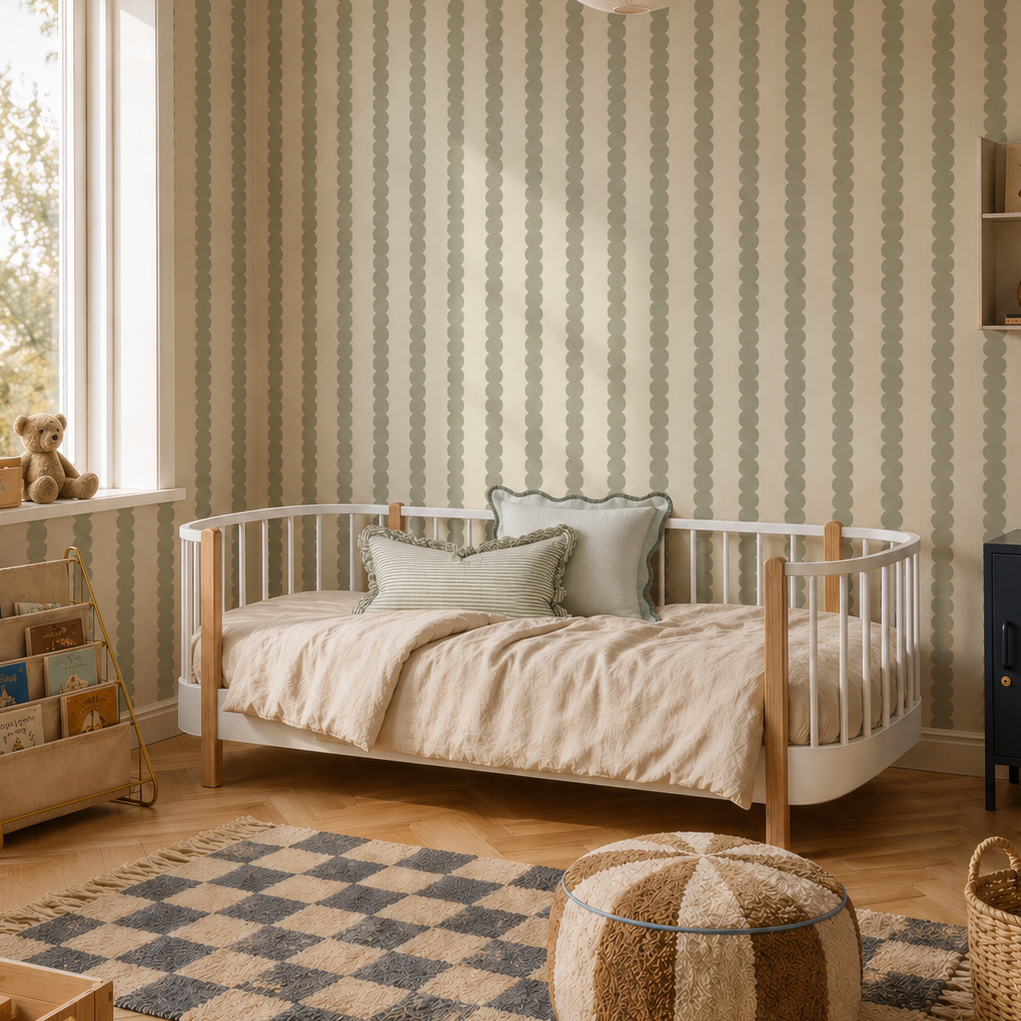 Cozy children’s bedroom featuring a round-edged bed, bookshelf, toys, woven storage baskets, a pouf, checkered rug on wooden floors, warm neutral tones throughout, and Scallop Stripe Wallpaper in Green. Large window lets in plenty of light.