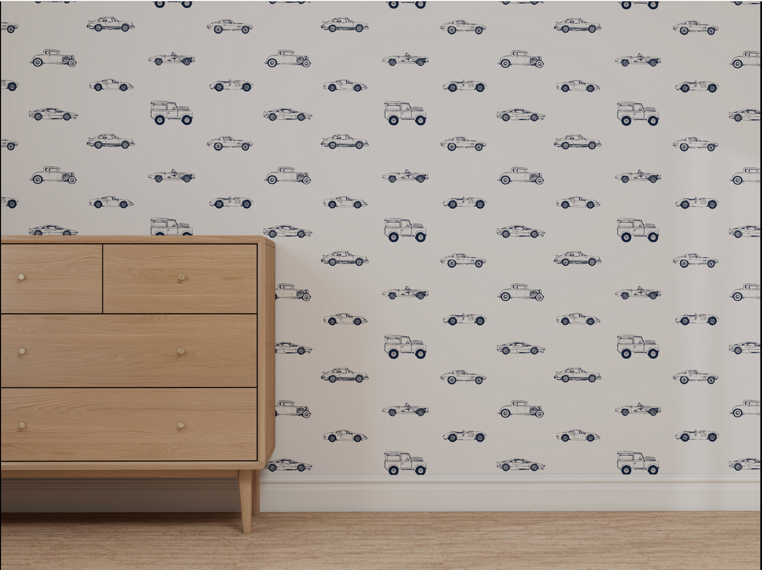 A minimalist room features a light wood dresser and a white wall covered in Custom Vintage Cars Wallpaper Repeat Pattern | Navy, displaying small, simple navy blue classic car designs. The floor is finished with beige carpet.