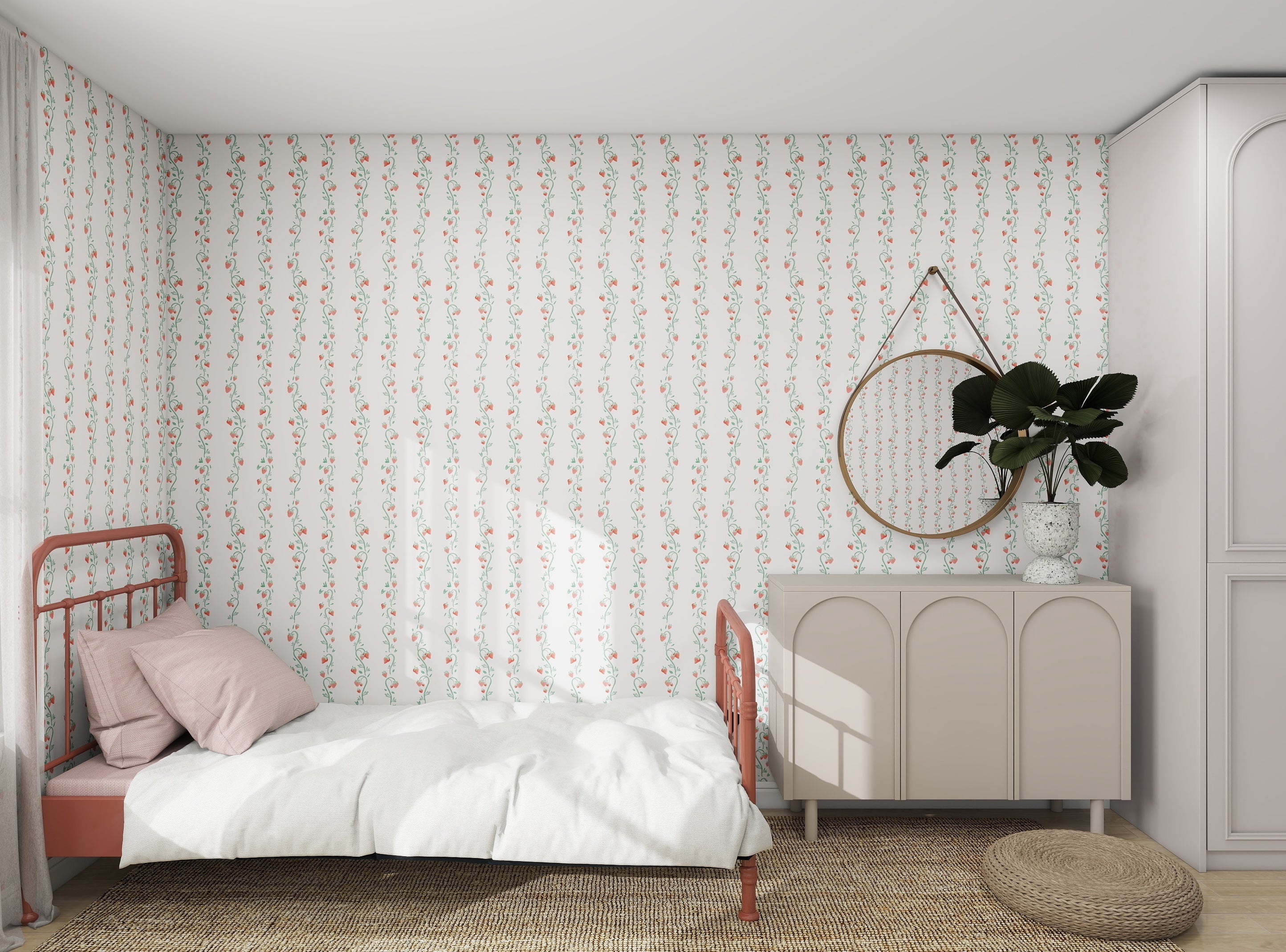 A bedroom showcases munks and mes Strawberry Stripes floral wallpaper, featuring a single bed with white bedding and a pink pillow. A round mirror above the cabinet holds a potted plant, while the woven rug complements the scheme as natural light enhances every color in this cozy space.