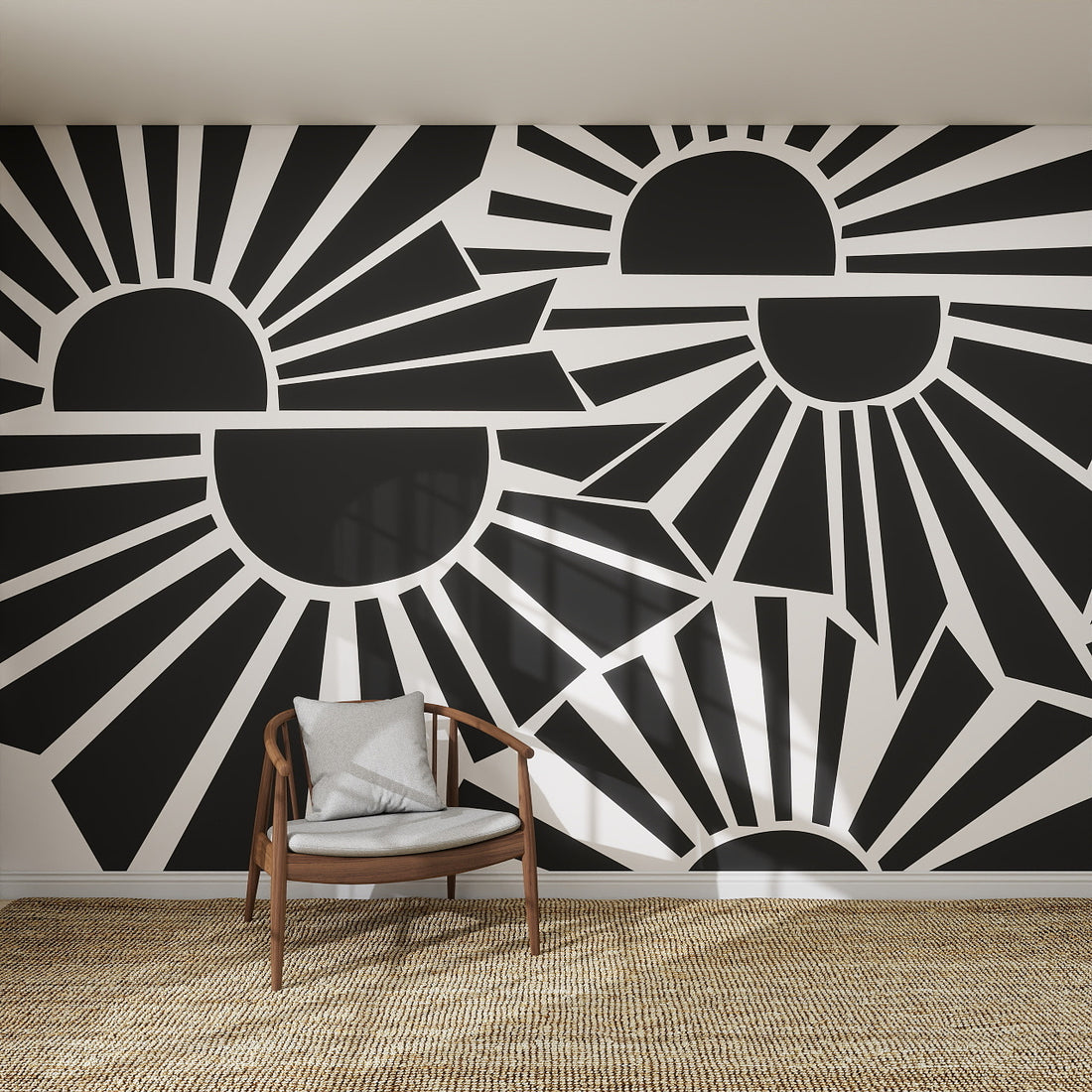 A modern room features the striking Sunbeams Wallpaper Repeat Pattern | Charcoal with geometric black and white stylized suns and rays, alongside a wooden chair with a cushion and a woven rug on the floor.
