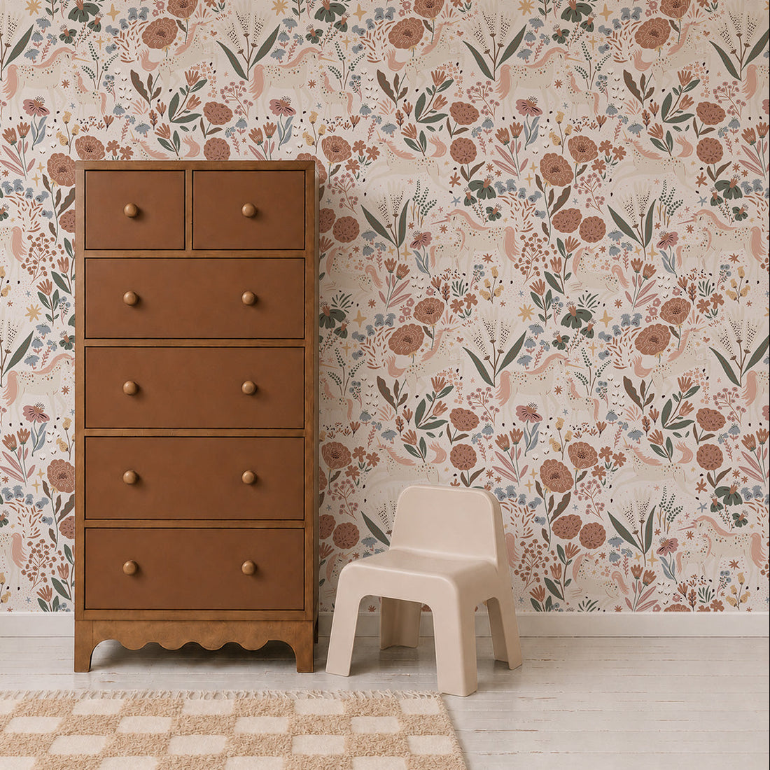 A tall brown dresser with round knobs stands beside a small white plastic chair in a room with girly decor, featuring Unicorn Meadow Wallpaper in cream and a beige checkered rug on a light wood floor.