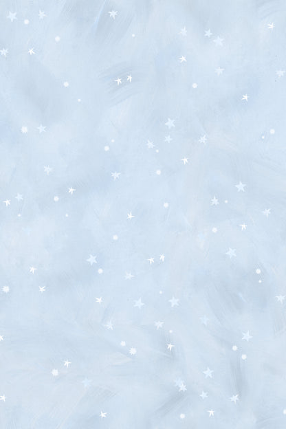The Painted Cloud Stars Wallpaper, Blue, features a light blue textured background with small white stars and dots for a soft, dreamy night sky look—ideal as celestial nursery decor.