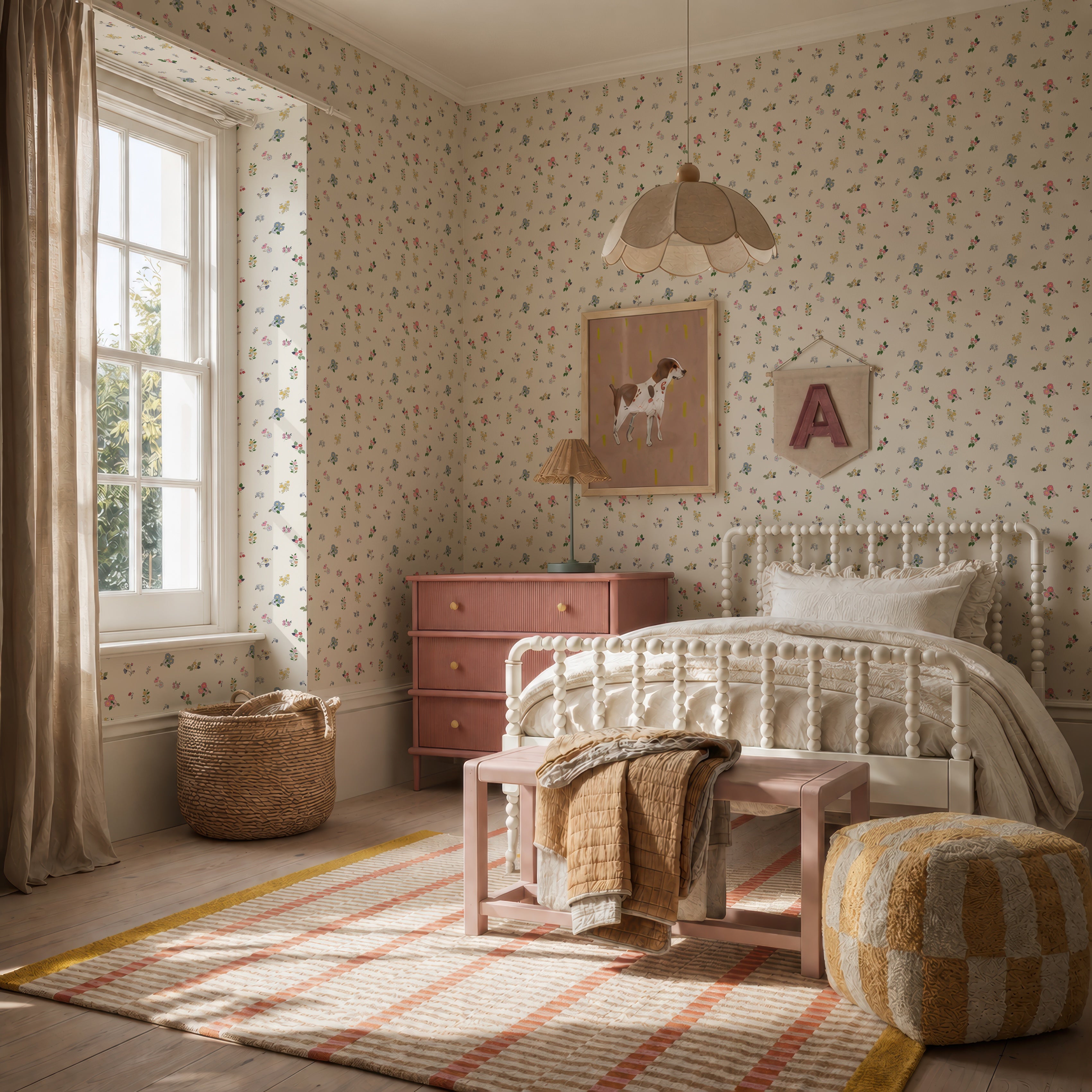 A cozy, sunlit bedroom features vibrant Powdered Petals Wallpaper, a white metal bed, pink dresser, woven basket, pouf, soft striped rug, framed dog art, and a letter A wall hanging for a warm and inviting feel.