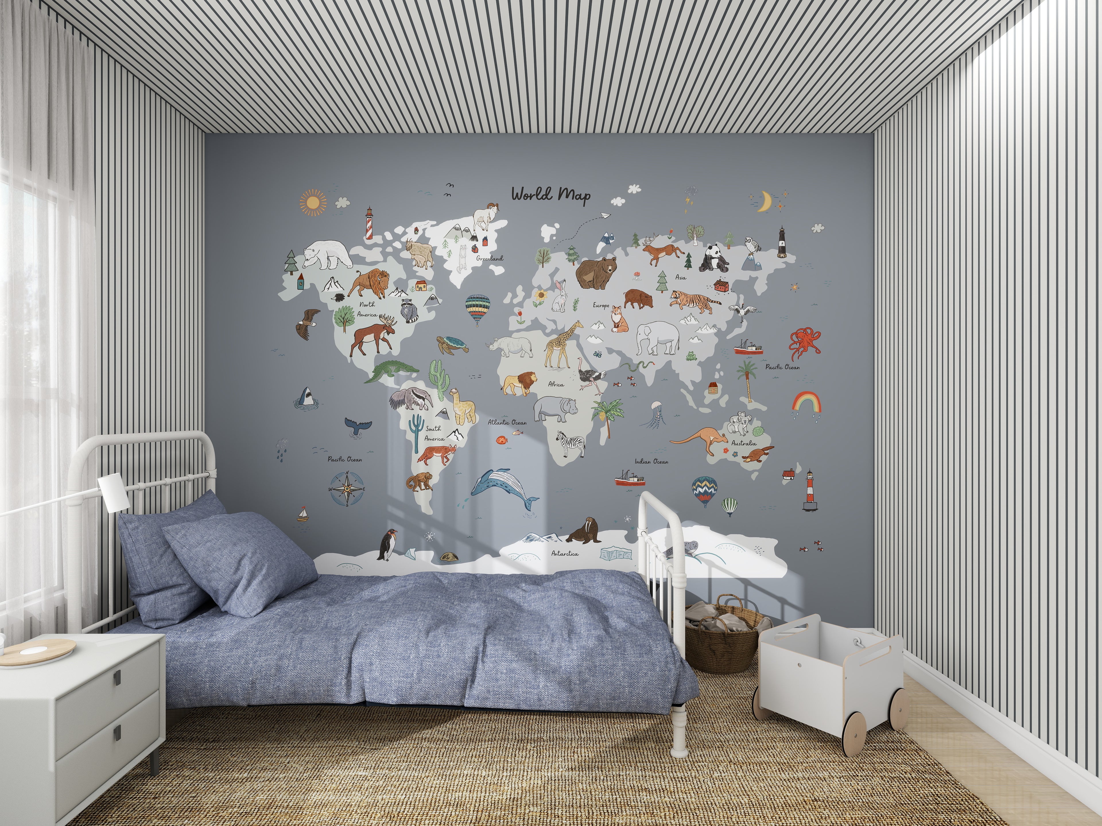 This childrens bedroom boasts a World Map Wallpaper Mural | Blue by munks and me, featuring cartoon animals and landmarks ideal for young geography fans. A cozy bed with blue bedding sits beside a white bedside table on the left, while a small wagon brings playfulness to the right side.