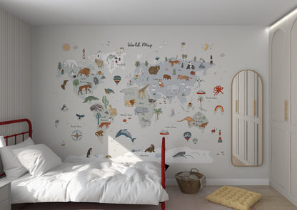 A childrens bedroom features the World Map Wallpaper Mural | Grey by munks and me, with animals and landmarks. It includes a red-framed bed, white bedding, and a wicker basket. Light gray walls are accented by a large mirror on the right.