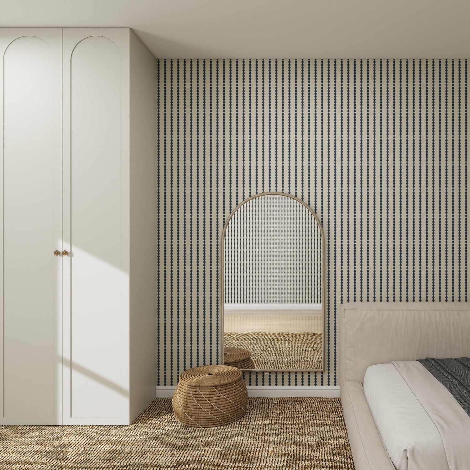A modern bedroom features Little Abacus Stripe Denim Wallpaper, a large arched mirror, a woven round pouf, a white wardrobe, and part of a beige bed with textured carpet on the floor.