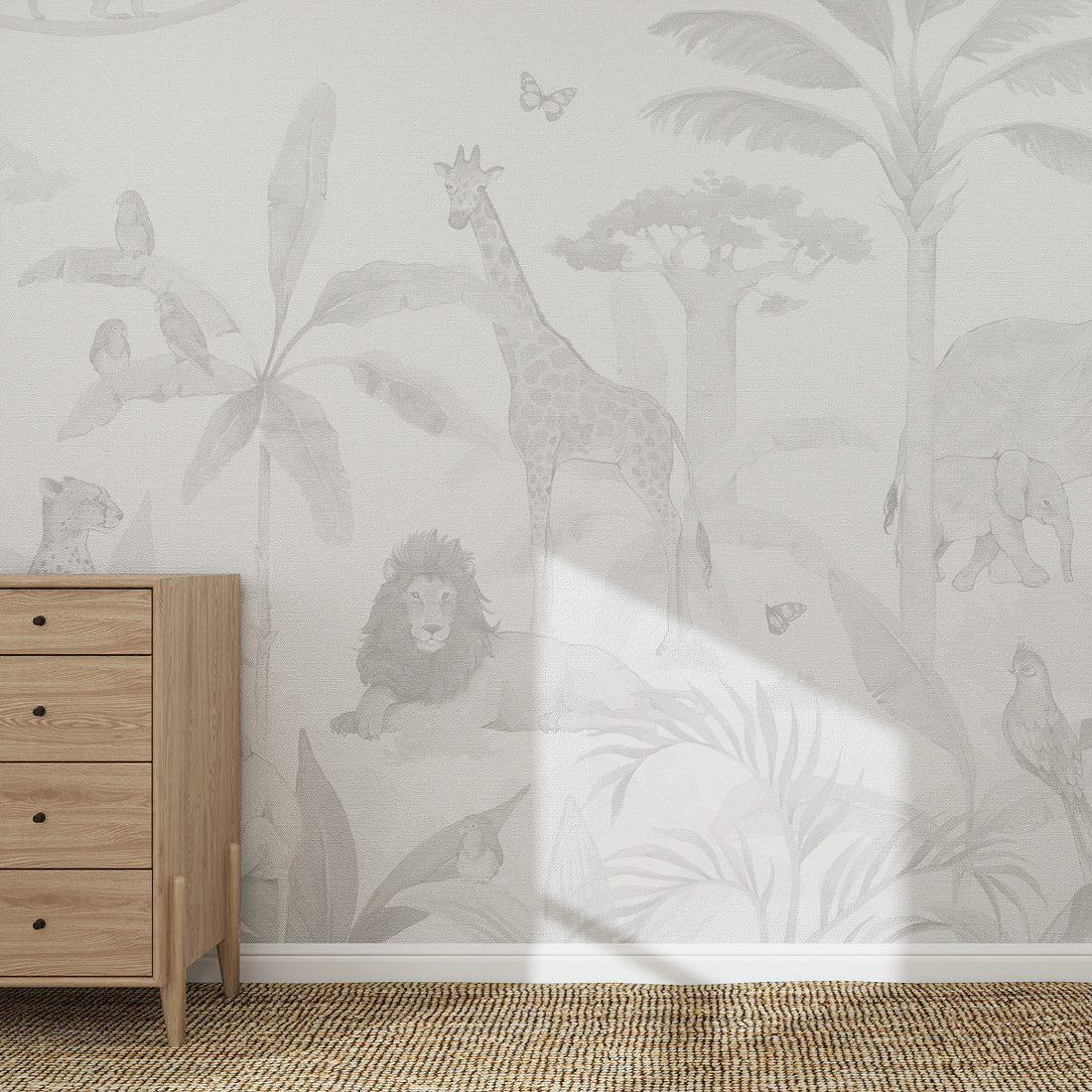 A nursery room with a light wood dresser on the left and the African Safari Mural, Grey wallpaper featuring outlined jungle animals—elephant, giraffe, lion, cheetah, parrots, and butterflies—among trees and plants.