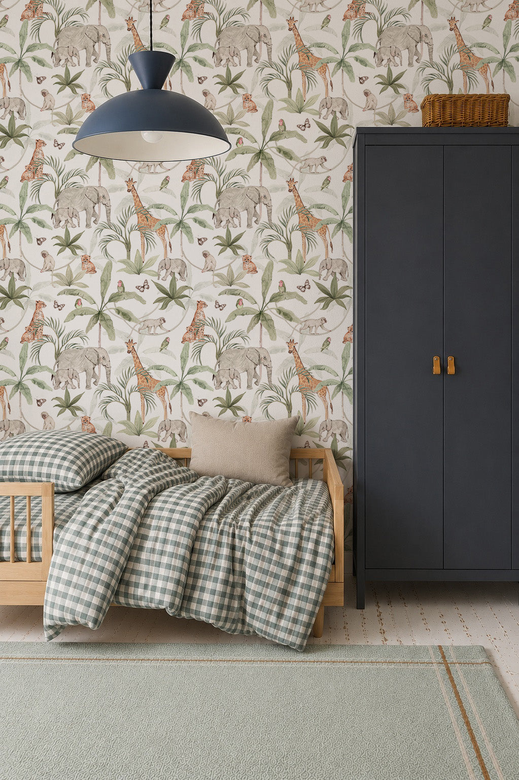 A cozy kids’ room features a small wooden bed with checkered bedding, gray pillow, dark wardrobe, and vibrant African Safari Wallpaper showcasing elephants, giraffes, and birds. A blue pendant lamp hangs overhead.
